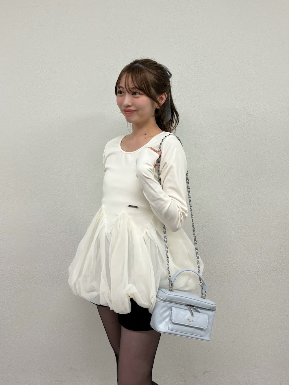 ホワイト系のTシャツ/カットソー、ブラック系のパンプス、ブルー系のショルダーバッグを着用したレディースの冬コーディネートの4枚目の写真