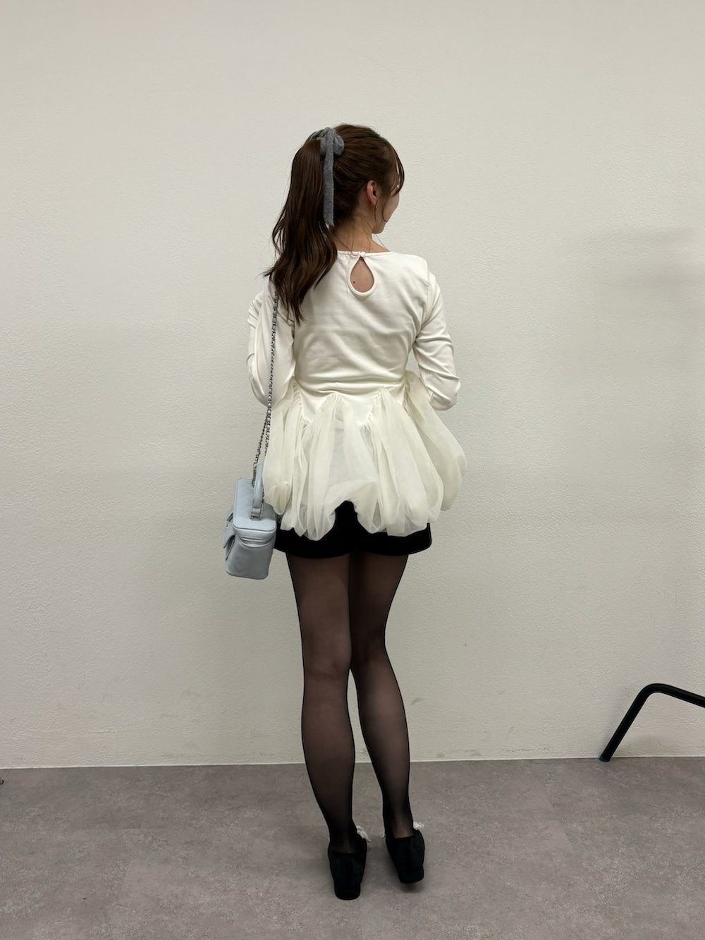 ホワイト系のTシャツ/カットソー、ブラック系のパンプス、ブルー系のショルダーバッグを着用したレディースの冬コーディネートの6枚目の写真