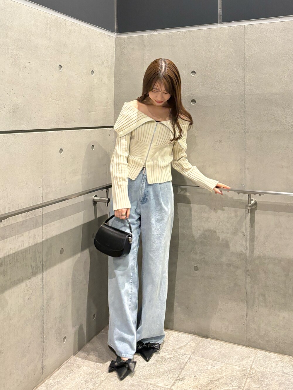 ブラック系のパンプス、ブルー系のデニムパンツ、ホワイト系のニット/セーターを着用したレディースの冬コーディネートの2枚目の写真