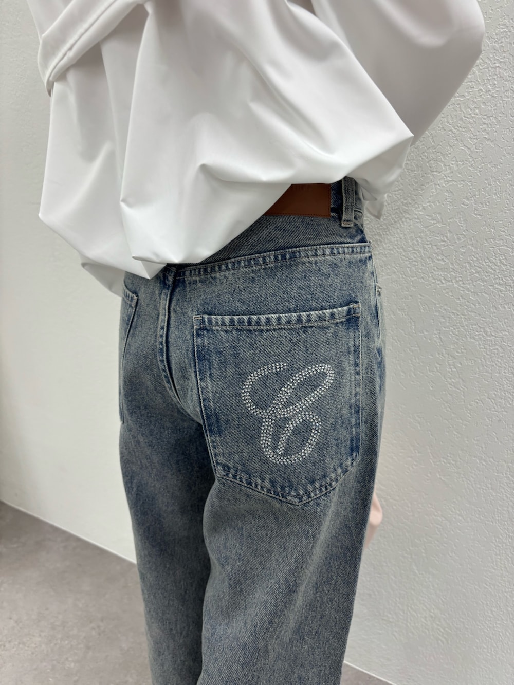 ホワイト系のシャツ/ブラウス、ブルー系のデニムパンツ、ピンク系のパンプスを着用したレディースの冬コーディネートの6枚目の写真