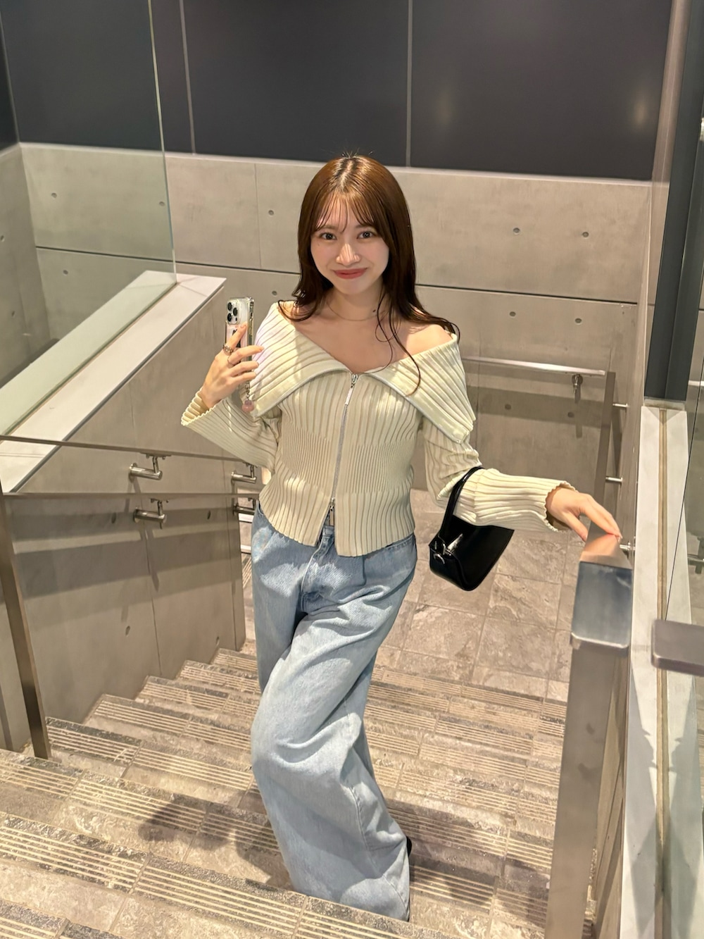ブラック系のパンプス、ブルー系のデニムパンツ、ホワイト系のニット/セーターを着用したレディースの冬コーディネートの3枚目の写真