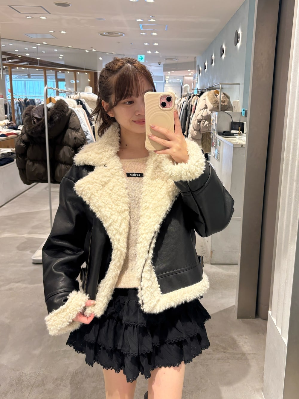 ブラック系のその他アウター、ブラック系のスカート、ブラック系のブーツを着用したレディースの冬コーディネートの3枚目の写真