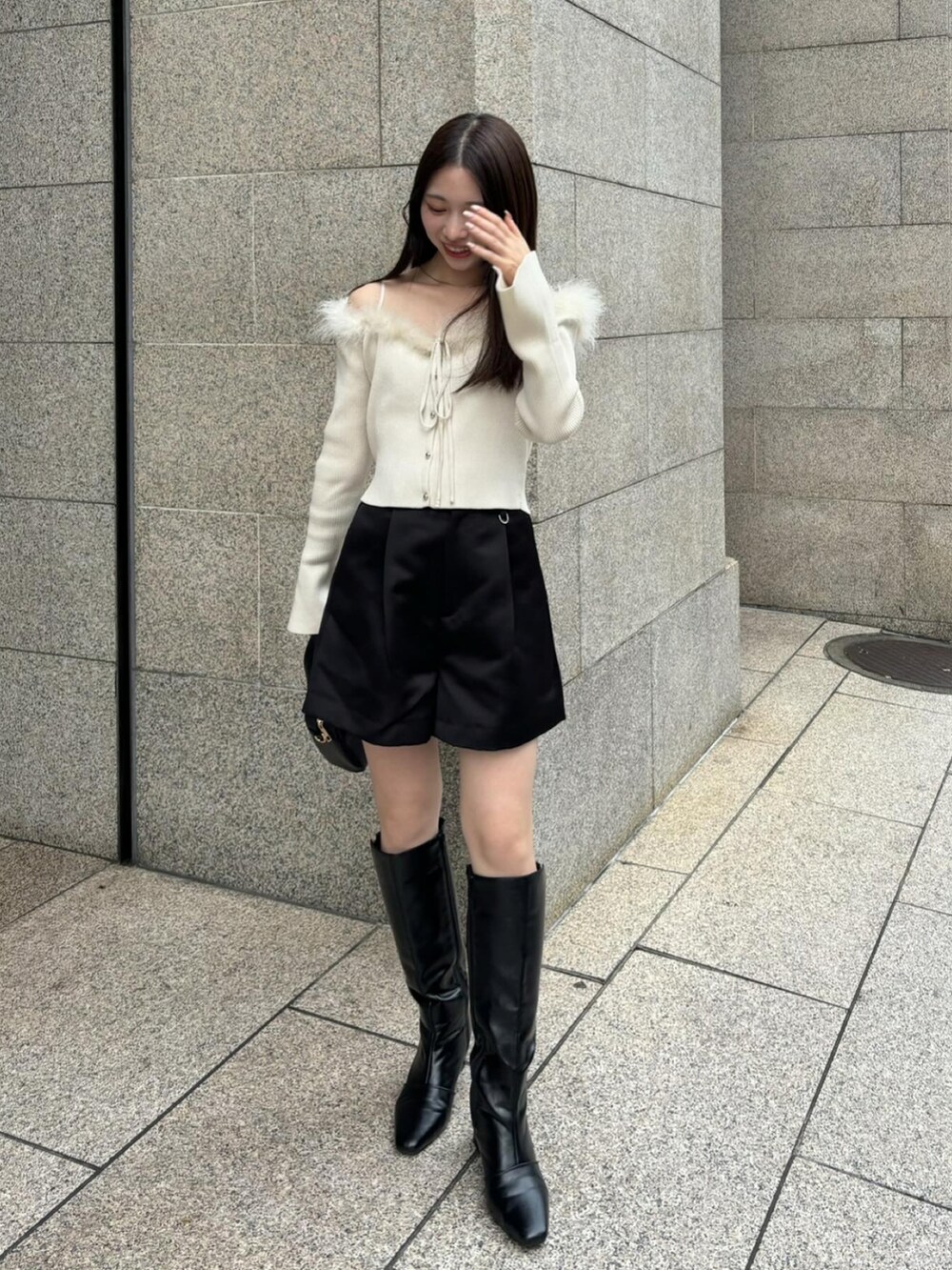 ブラック系のブーツ、ブラック系のその他パンツ、ホワイト系のニット/セーターを着用したレディースの秋コーディネートの3枚目の写真