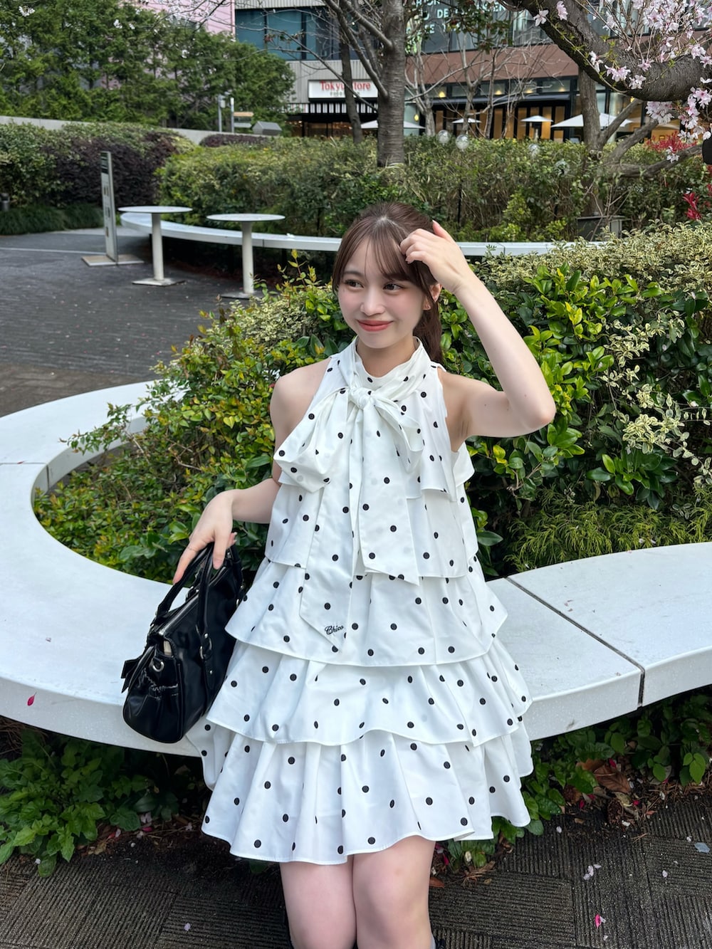 ホワイト系のワンピース、ホワイト系のカーディガン/ボレロ、ブラック系のボストンバッグを着用したレディースの春コーディネートの5枚目の写真