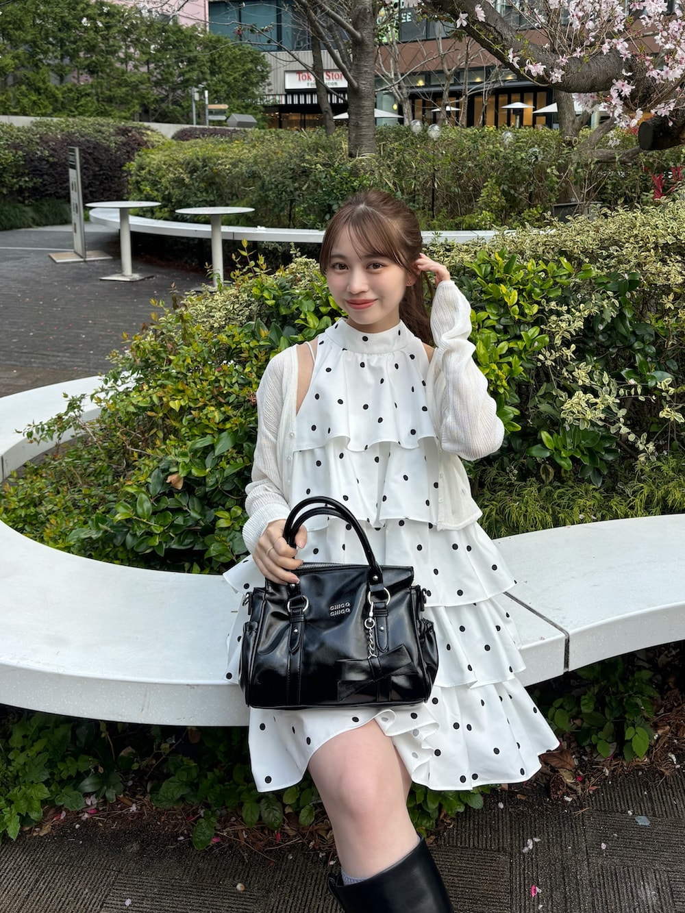 ホワイト系のワンピース、ホワイト系のカーディガン/ボレロ、ブラック系のボストンバッグを着用したレディースの春コーディネートの4枚目の写真
