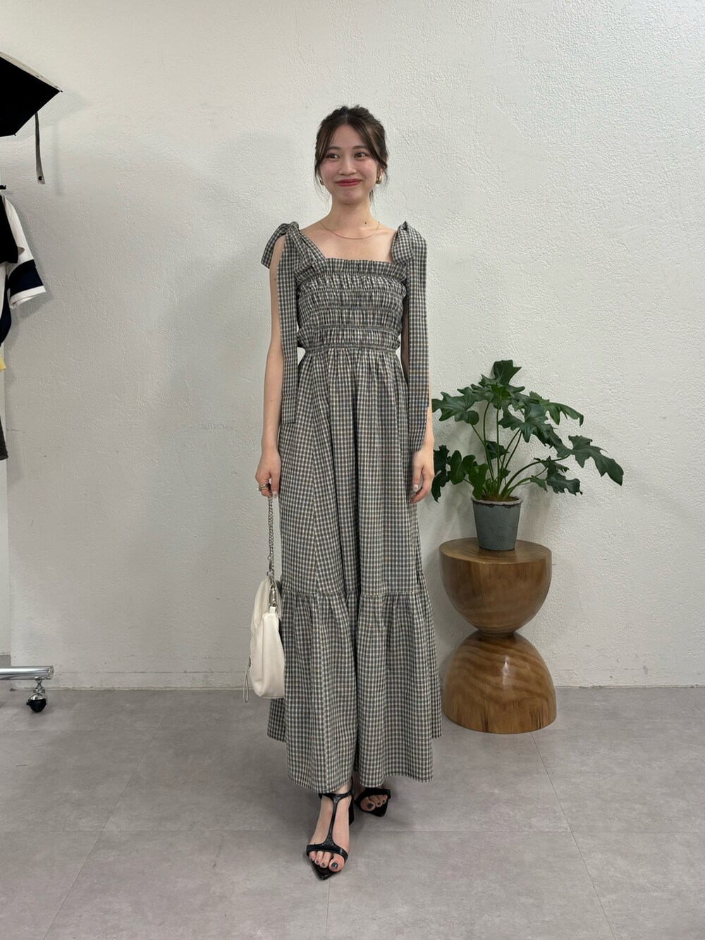 ブラック系のワンピース、ホワイト系のショルダーバッグ、ブラック系のサンダルを着用したレディースの夏コーディネートの2枚目の写真