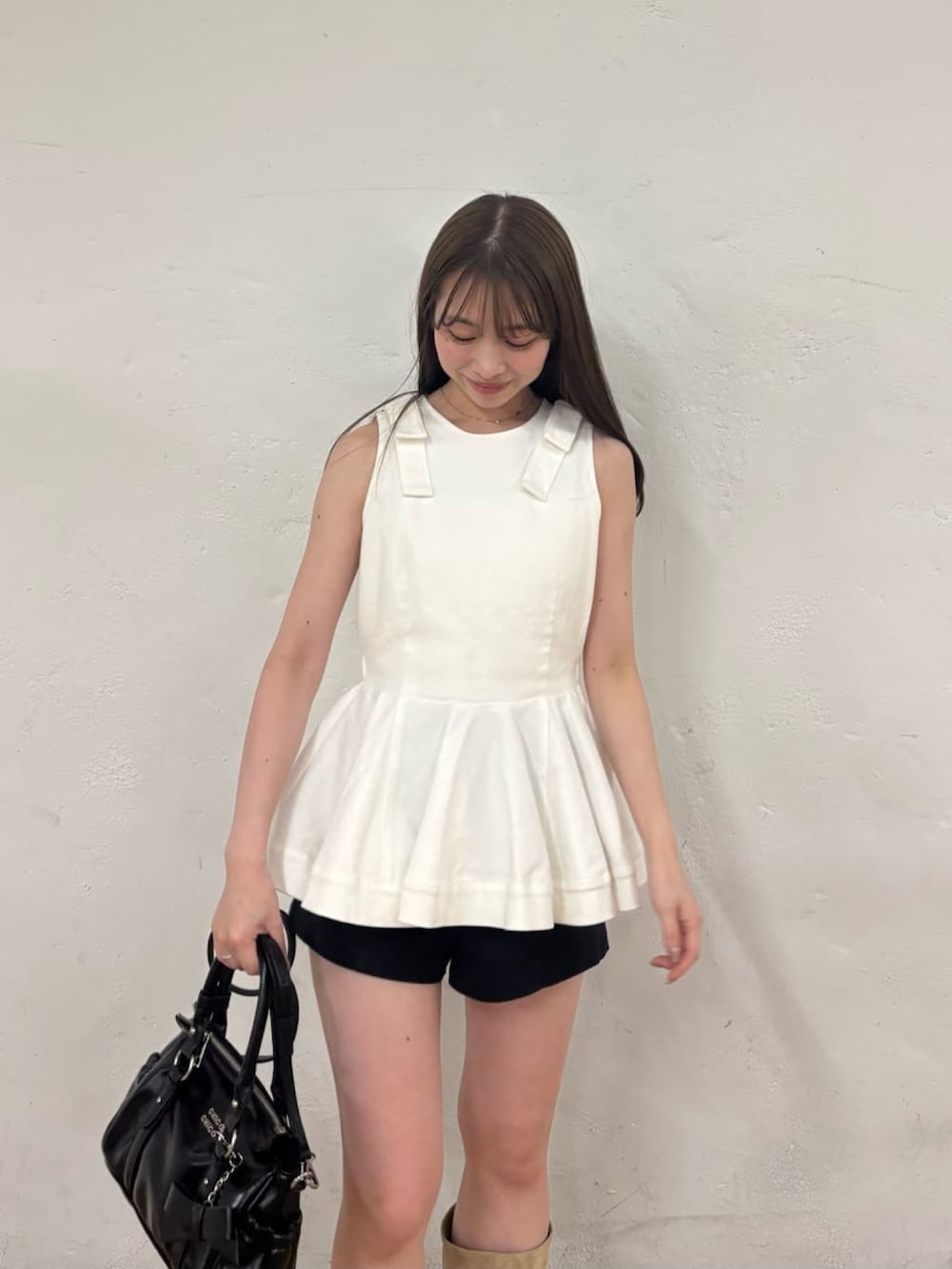 ホワイト系のシャツ/ブラウス、ブラック系のその他パンツ、ベージュ系のブーツを着用したレディースの夏コーディネートの3枚目の写真