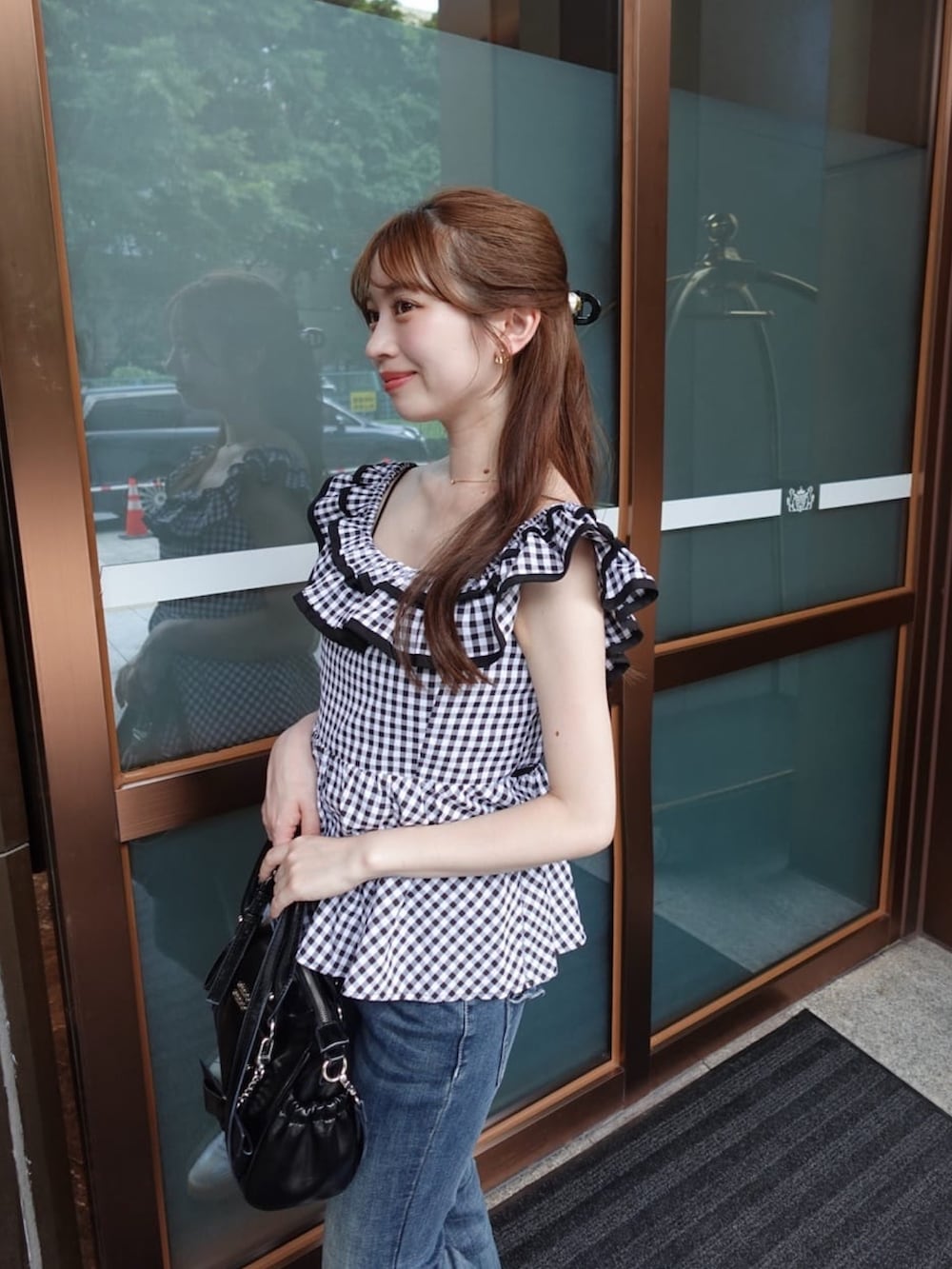 ホワイト系のシャツ/ブラウス、ブラック系のボストンバッグを着用したレディースの夏コーディネートの2枚目の写真