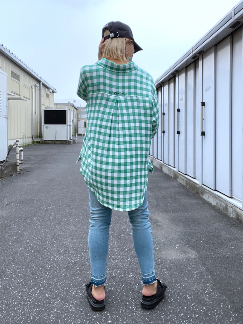 グリーン系のシャツ/ブラウス、ブルー系のデニムパンツ、ブラック系のキャップを着用したレディースの夏コーディネートの2枚目の写真