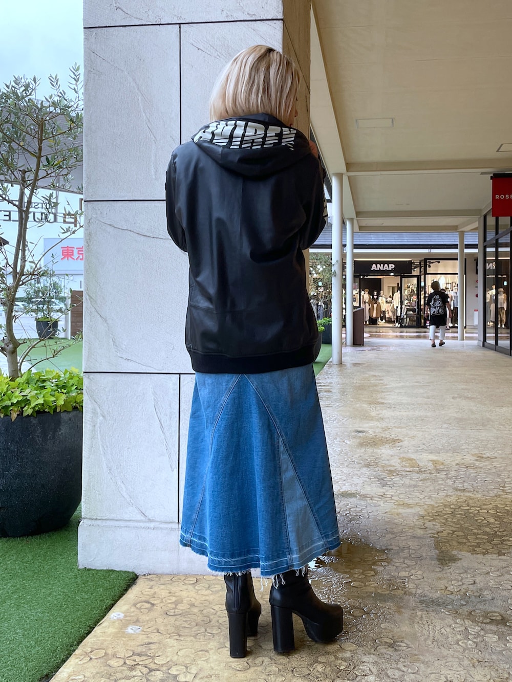 レッド系のライダースジャケット、ブルー系のデニムスカート、ホワイト系のTシャツ/カットソーを着用したレディースの秋コーディネートの2枚目の写真