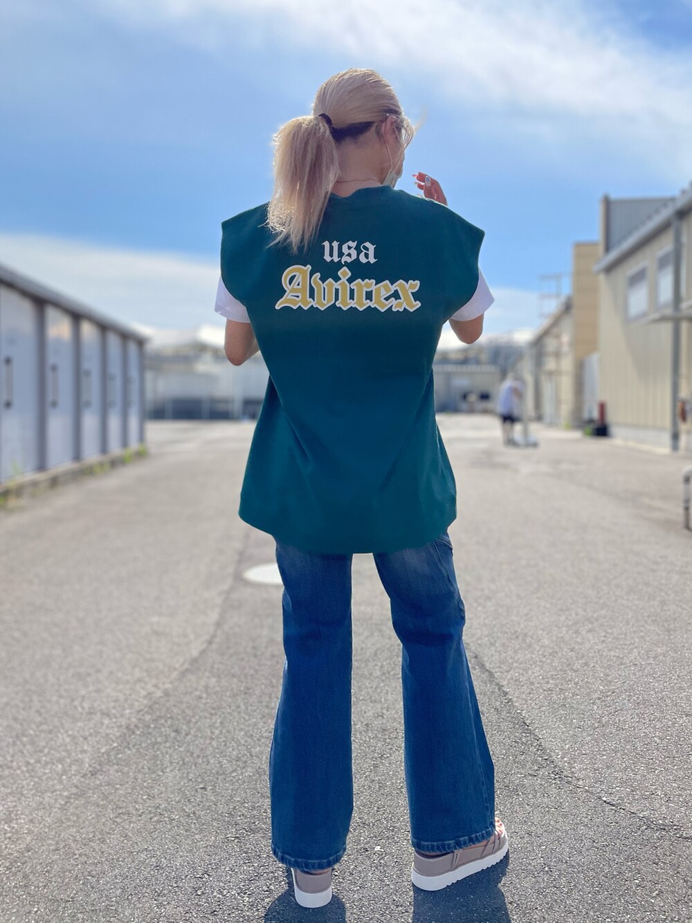 グリーン系のタンクトップ、ホワイト系のTシャツ/カットソー、ブルー系のデニムパンツを着用したレディースの夏コーディネートの2枚目の写真