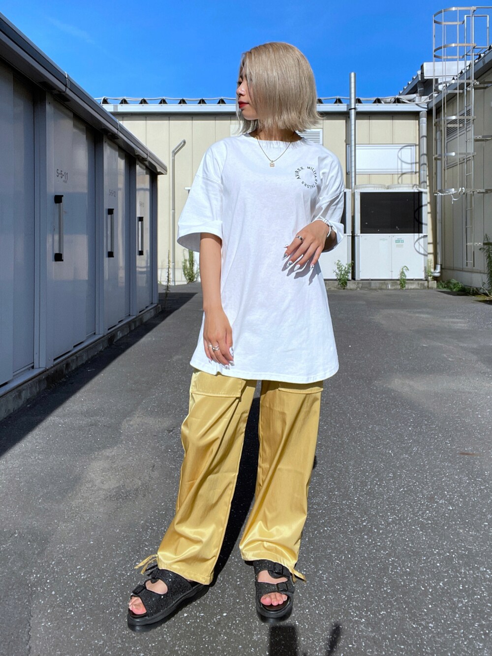 ホワイト系のチュニック、イエロー系のその他パンツを着用したレディースの夏コーディネートの2枚目の写真