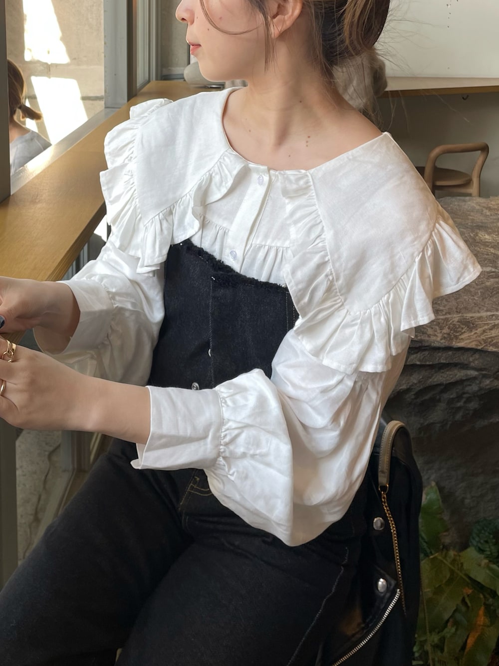 ブラック系のデニムパンツ、ホワイト系のシャツ/ブラウス、ホワイト系のブーツを着用したレディースの春コーディネートの4枚目の写真