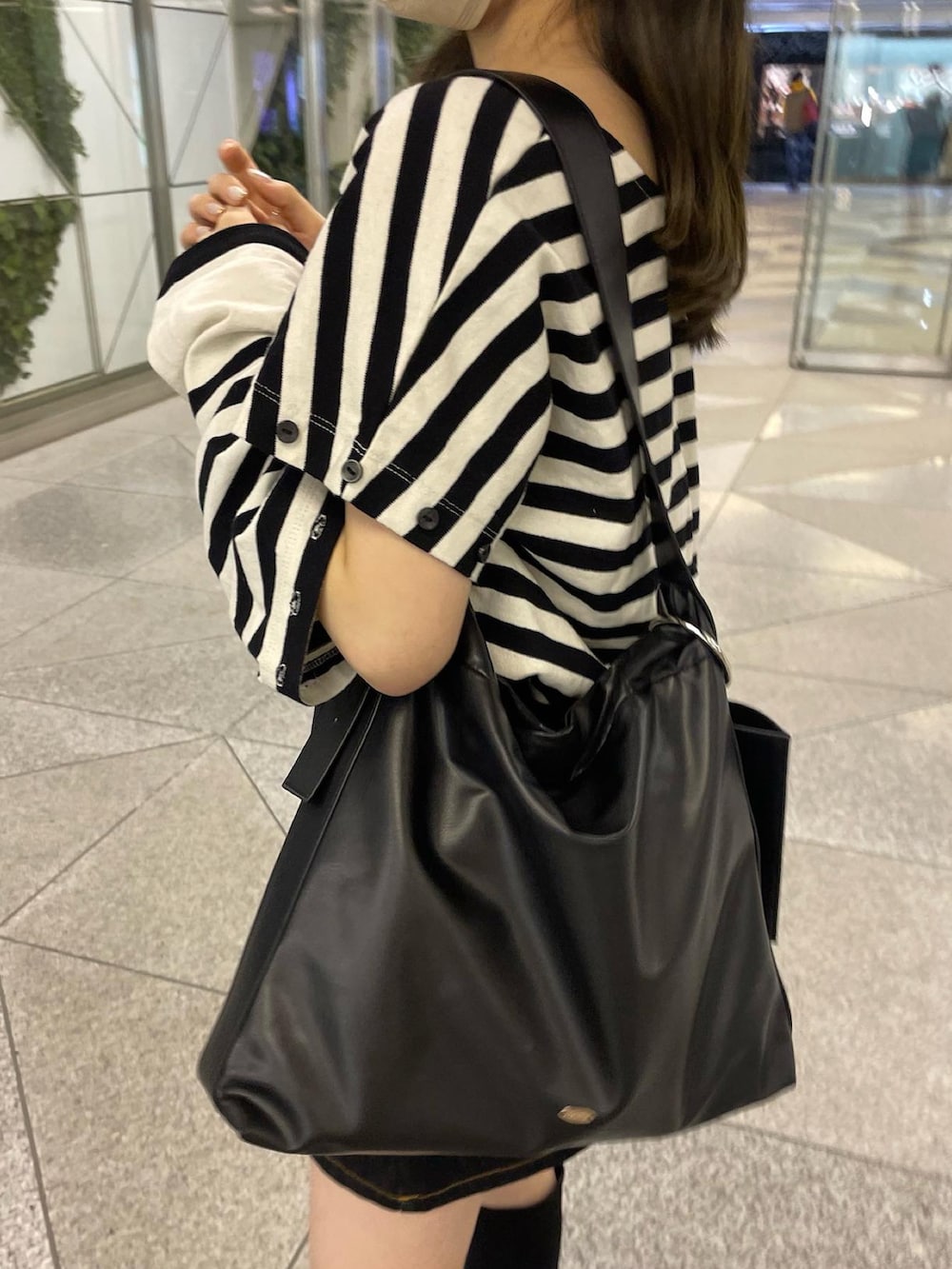 ホワイト系のTシャツ/カットソー、ブラック系のデニムスカートを着用したレディースの春コーディネートの4枚目の写真