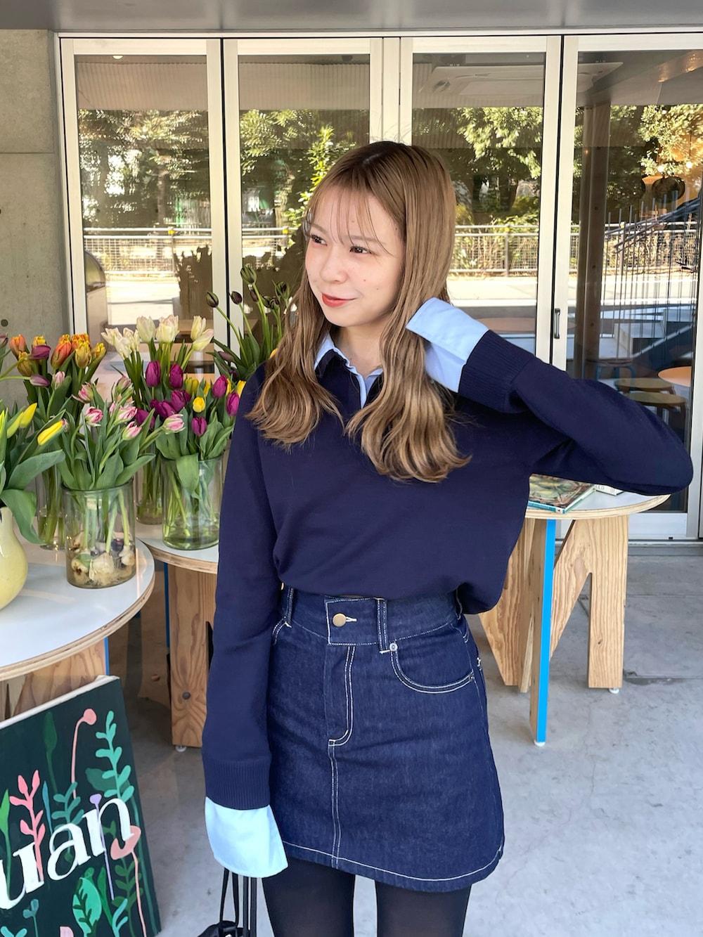 ブルー系のニット/セーター、ブルー系のデニムスカート、ホワイト系のスニーカーを着用したレディースの冬コーディネートの3枚目の写真