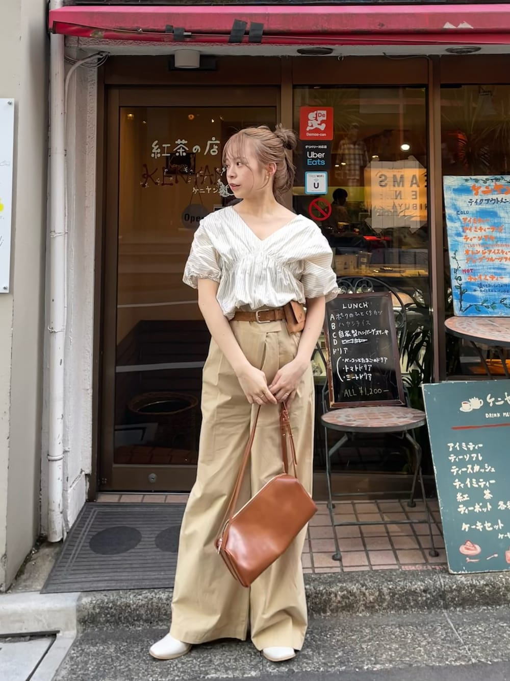 ホワイト系のシャツ/ブラウス、ベージュ系のその他パンツ、ブラウン系のハンドバッグを着用したレディースの春コーディネートの2枚目の写真