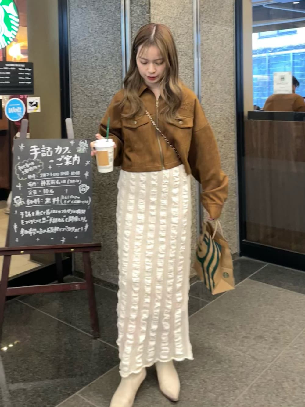 ベージュ系のスカート、イエロー系のブルゾン、ホワイト系のブーツを着用したレディースの春コーディネートの4枚目の写真