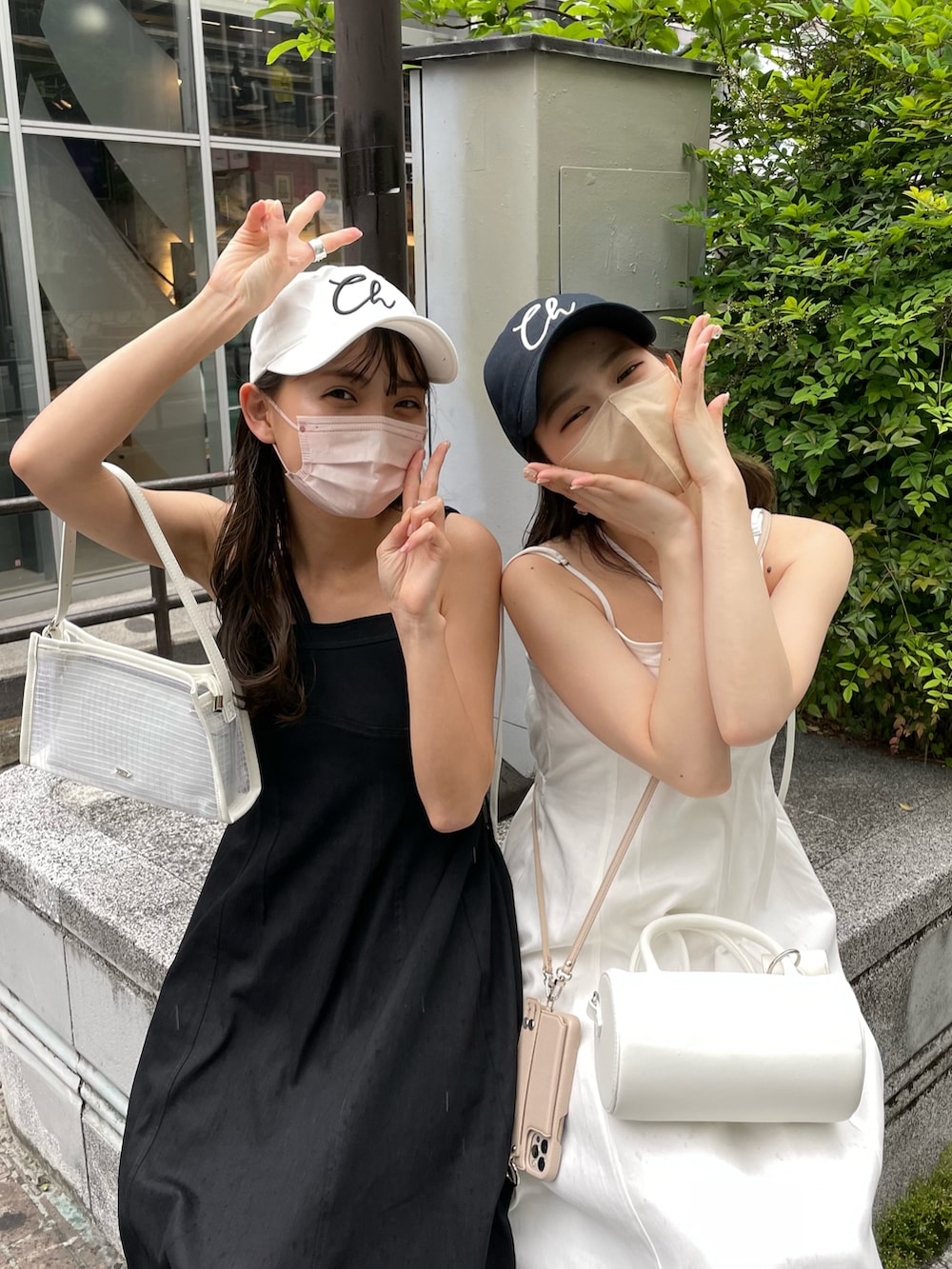 ブラック系のワンピース、ホワイト系のサンダル、ホワイト系のショルダーバッグを着用したレディースの春コーディネートの3枚目の写真