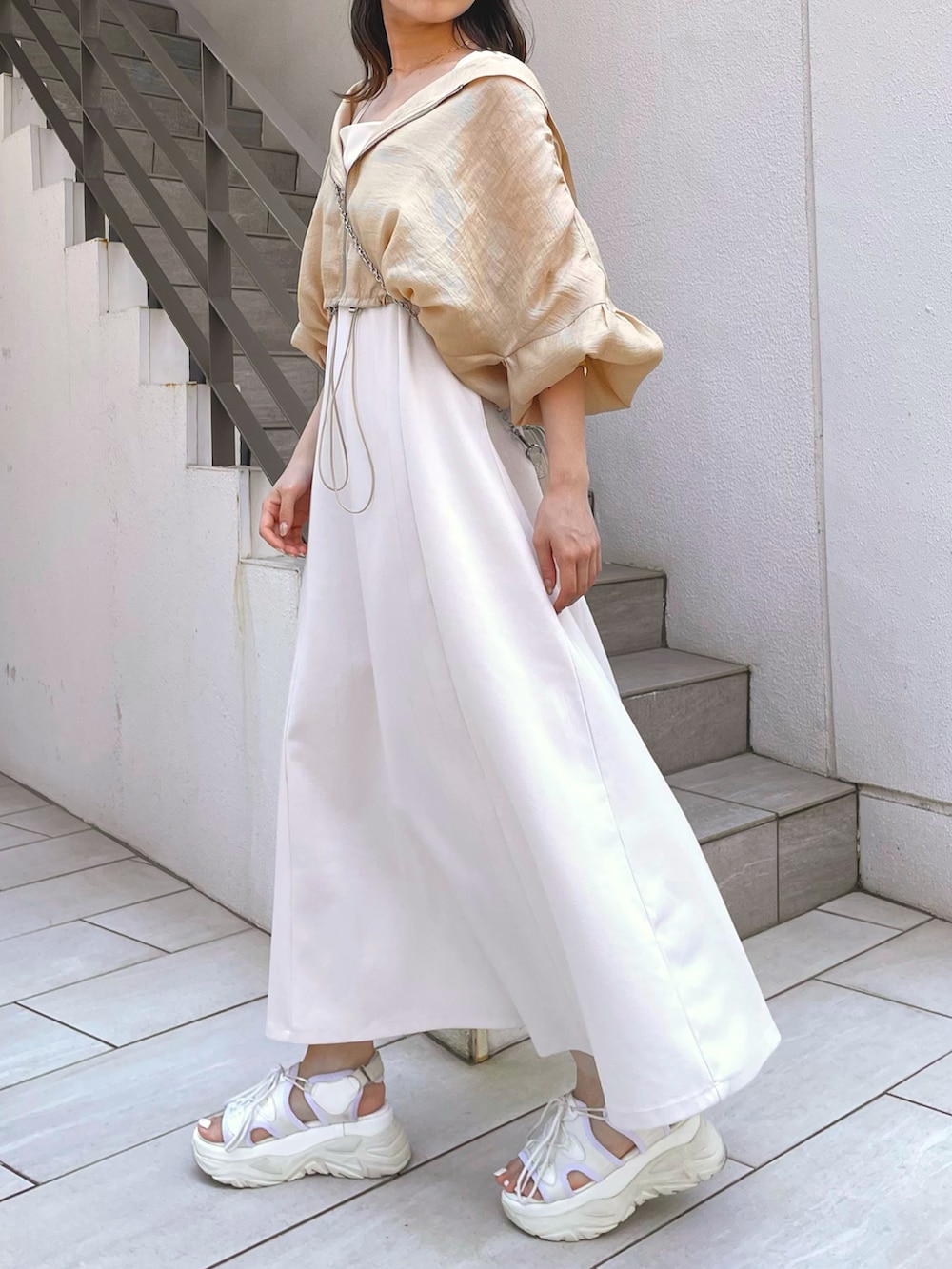 ベージュ系のブルゾン、ホワイト系のワンピースを着用したレディースの夏コーディネートの3枚目の写真