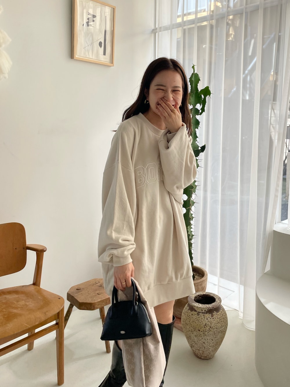 ホワイト系のスウェット、ブラック系のブーツを着用したレディースの夏コーディネートの3枚目の写真