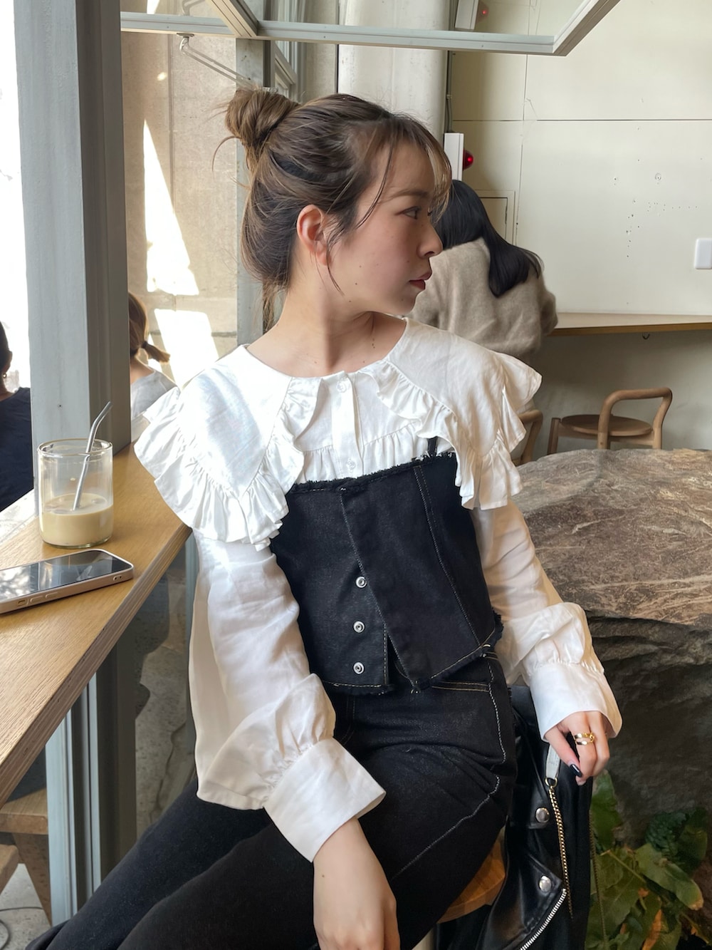 ブラック系のデニムパンツ、ホワイト系のシャツ/ブラウス、ホワイト系のブーツを着用したレディースの春コーディネートの3枚目の写真