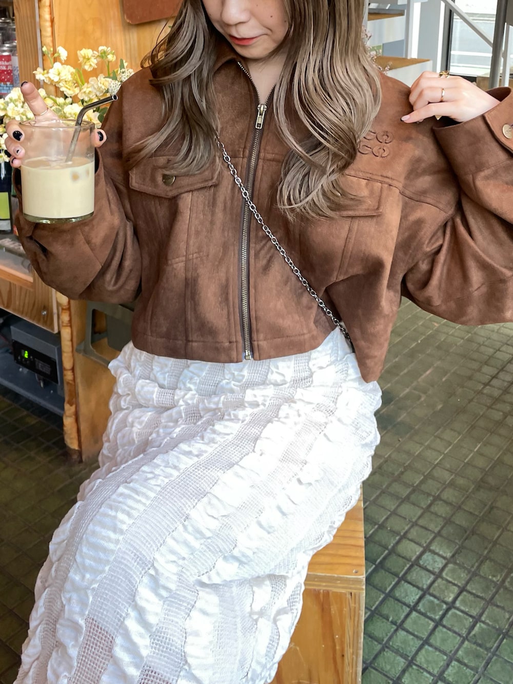 ベージュ系のスカート、イエロー系のブルゾン、ホワイト系のブーツを着用したレディースの春コーディネートの5枚目の写真