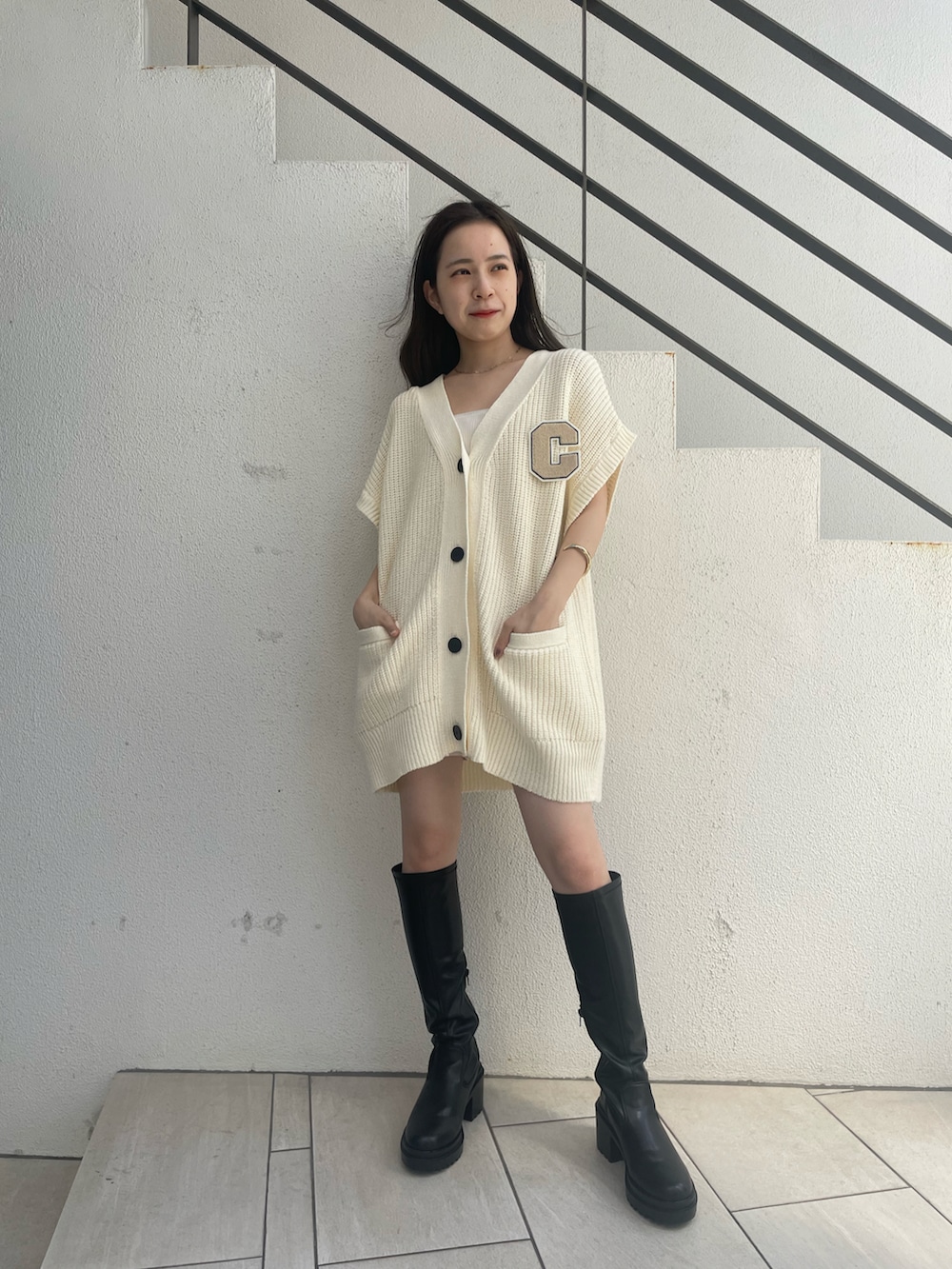 ホワイト系のカーディガン/ボレロ、ホワイト系のキャミソール、ブラック系のブーツを着用したレディースの夏コーディネートの4枚目の写真