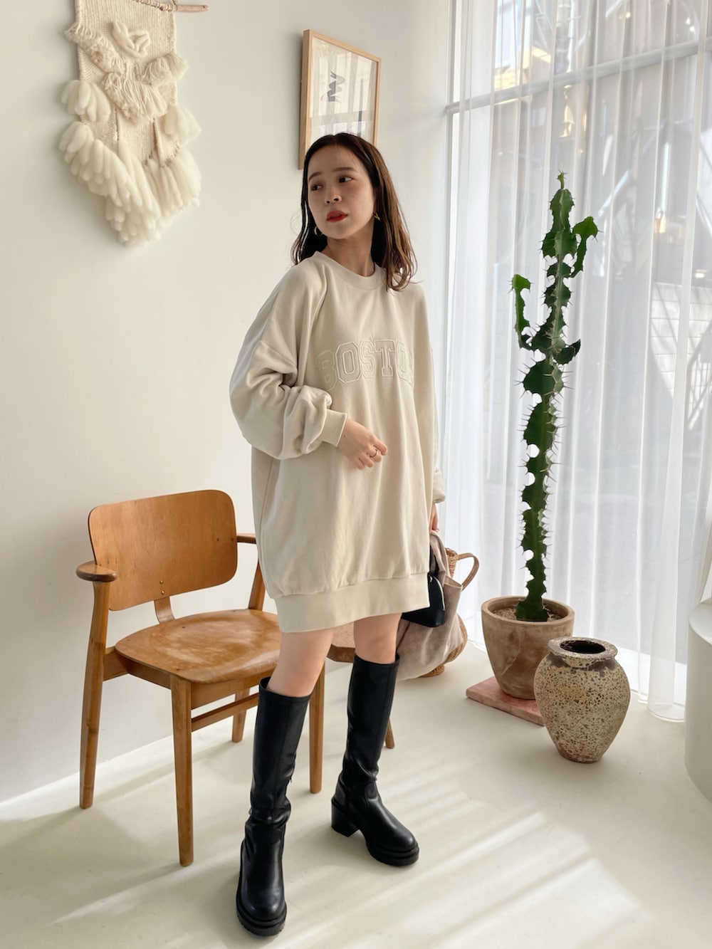 ホワイト系のスウェット、ブラック系のブーツを着用したレディースの夏コーディネートの2枚目の写真