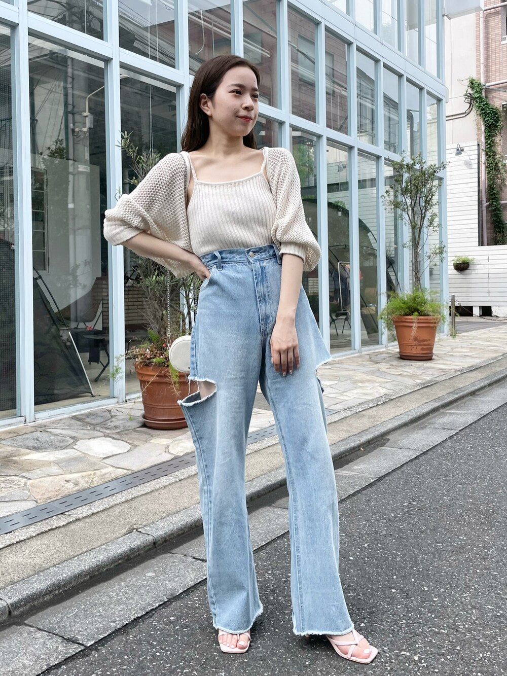 ホワイト系のカーディガン/ボレロ、ブルー系のデニムパンツを着用したレディースの春コーディネートの2枚目の写真