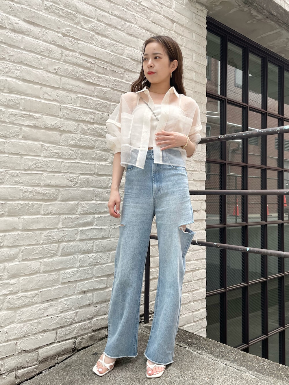 ホワイト系のシャツ/ブラウス、ブルー系のデニムパンツを着用したレディースの春コーディネートの2枚目の写真