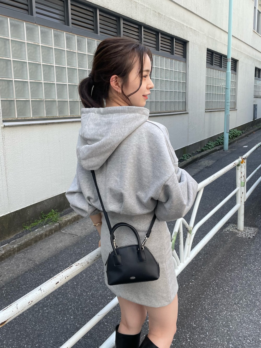 グレー系のワンピース、ブラック系のブーツを着用したレディースの秋コーディネートの4枚目の写真