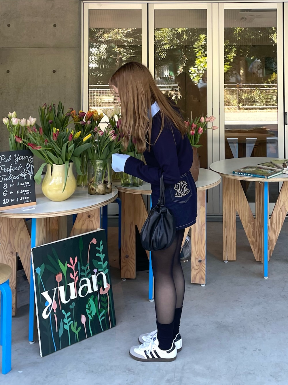 ブルー系のニット/セーター、ブルー系のデニムスカート、ホワイト系のスニーカーを着用したレディースの冬コーディネートの2枚目の写真