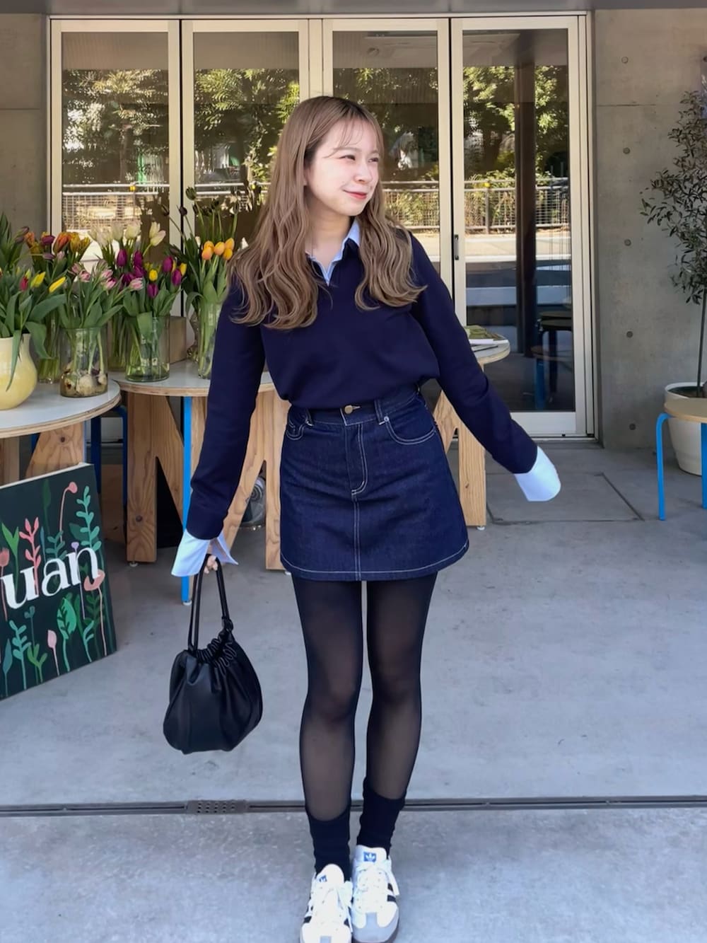 ブルー系のニット/セーター、ブルー系のデニムスカート、ホワイト系のスニーカーを着用したレディースの冬コーディネートの4枚目の写真