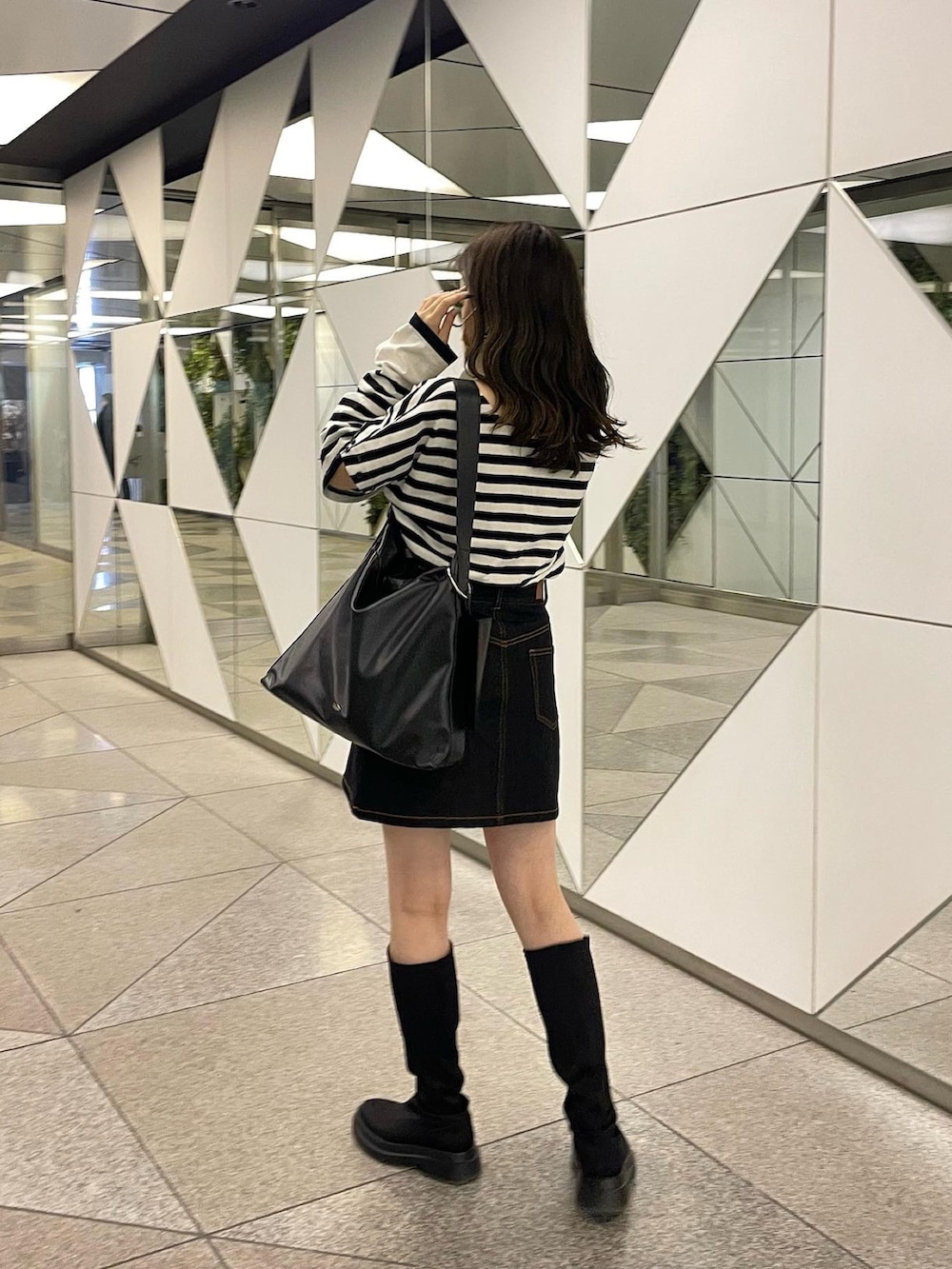 ホワイト系のTシャツ/カットソー、ブラック系のデニムスカートを着用したレディースの春コーディネートの3枚目の写真