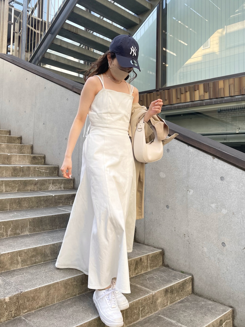 ホワイト系のワンピース、グリーン系のハンドバッグ、ホワイト系のスニーカーを着用したレディースの春コーディネートの2枚目の写真