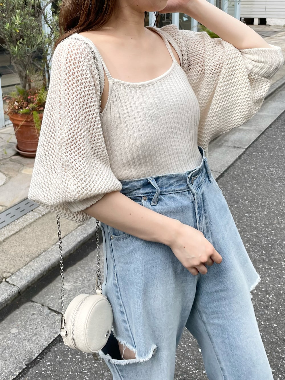 ホワイト系のカーディガン/ボレロ、ブルー系のデニムパンツを着用したレディースの春コーディネートの3枚目の写真