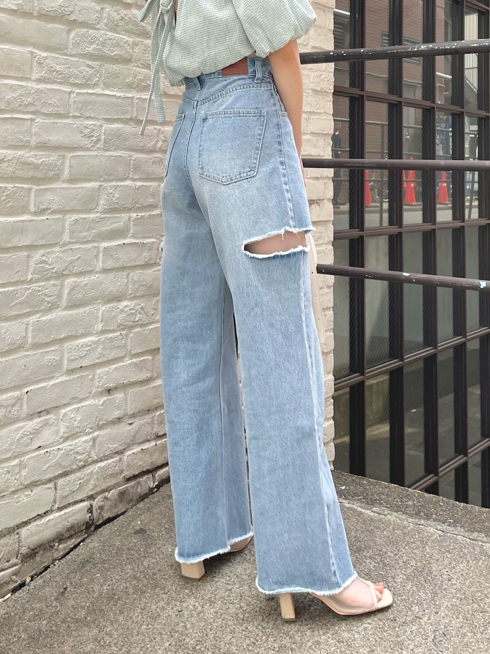 ブルー系のデニムパンツ、グリーン系のシャツ/ブラウス、ホワイト系のハンドバッグを着用したレディースの春コーディネートの3枚目の写真