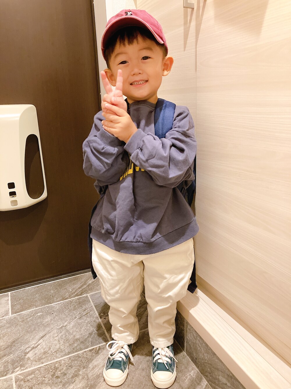 ブルー系のスウェット、ホワイト系のその他パンツ、グリーン系のスニーカーを着用したキッズの秋コーディネートの2枚目の写真