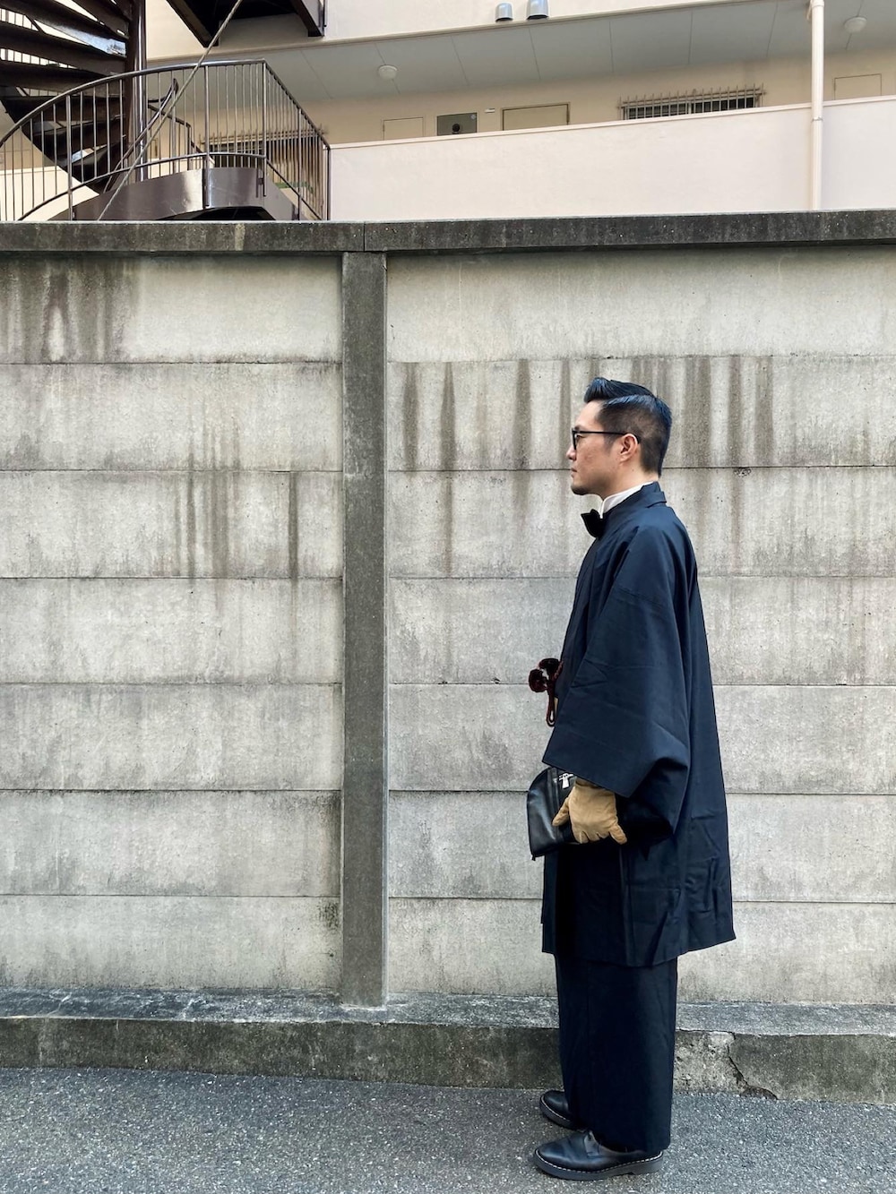 ブラック系のブーツ、ブラック系の蝶ネクタイ、ブラック系のクラッチバッグを着用したメンズの冬コーディネートの4枚目の写真