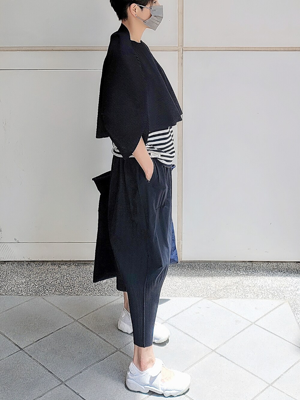 ブラック系のチノパンツ、ブラック系のトートバッグ、ブラック系のその他トップスを着用したレディースの春コーディネートの2枚目の写真