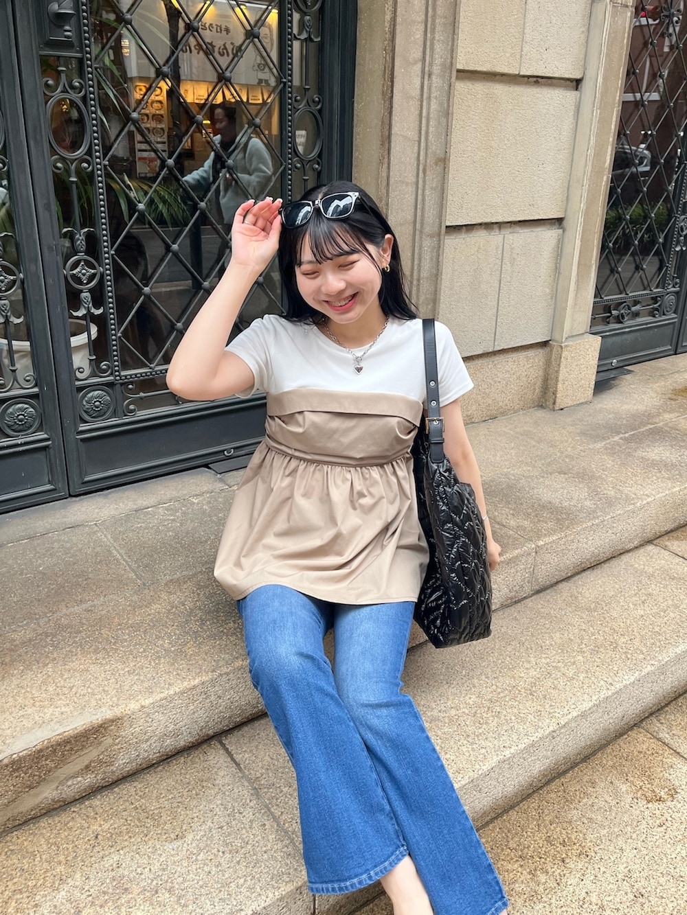 ブルー系のデニムパンツ、ブラック系のパンプス、ホワイト系のTシャツ/カットソーを着用したレディースの春コーディネートの4枚目の写真