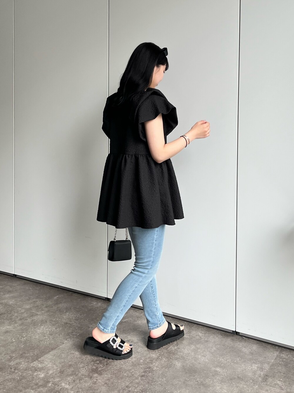 ブラック系のシャツ/ブラウス、ブルー系のデニムパンツ、ブラック系のサンダルを着用したレディースの春コーディネートの4枚目の写真