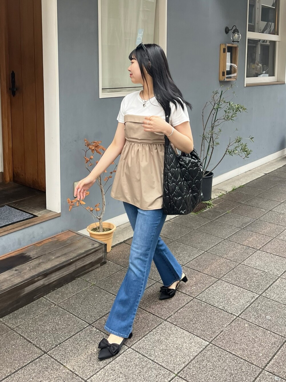 ブルー系のデニムパンツ、ブラック系のパンプス、ホワイト系のTシャツ/カットソーを着用したレディースの春コーディネートの2枚目の写真