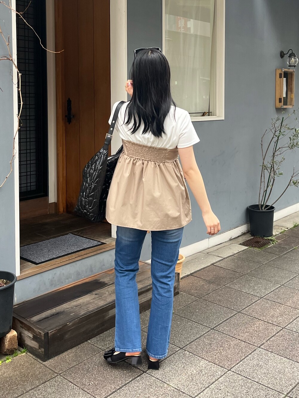 ブルー系のデニムパンツ、ブラック系のパンプス、ホワイト系のTシャツ/カットソーを着用したレディースの春コーディネートの3枚目の写真