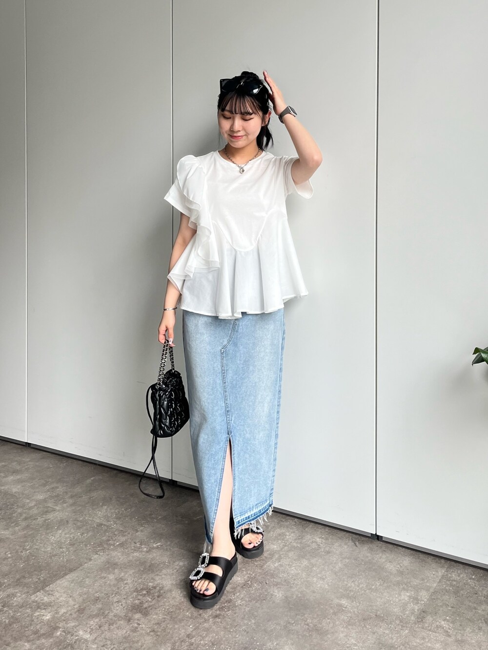 ホワイト系のTシャツ/カットソー、ブルー系のデニムスカート、ブラック系のサンダルを着用したレディースの春コーディネートの5枚目の写真