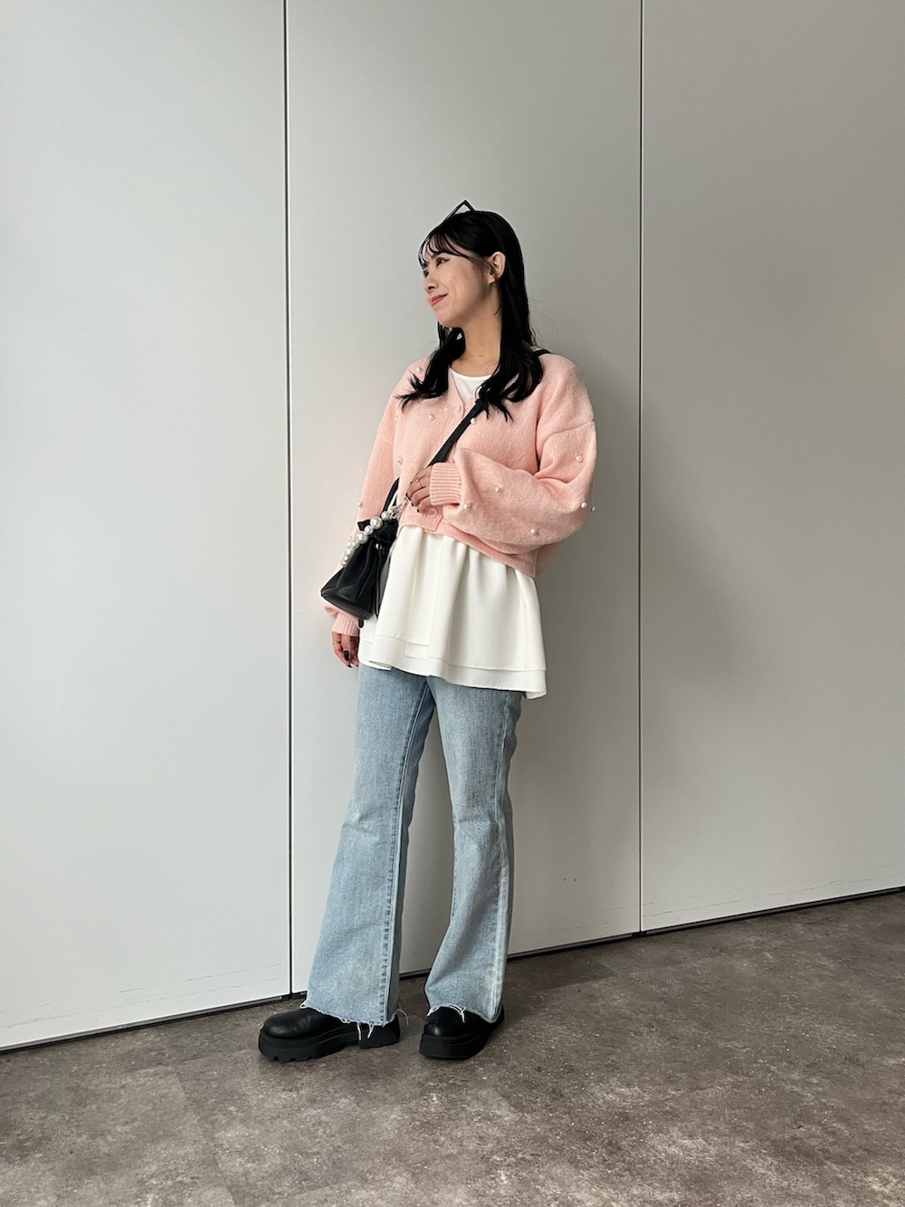 ホワイト系のTシャツ/カットソー、ピンク系のカーディガン/ボレロ、ブルー系のデニムパンツを着用したレディースの秋コーディネートの3枚目の写真