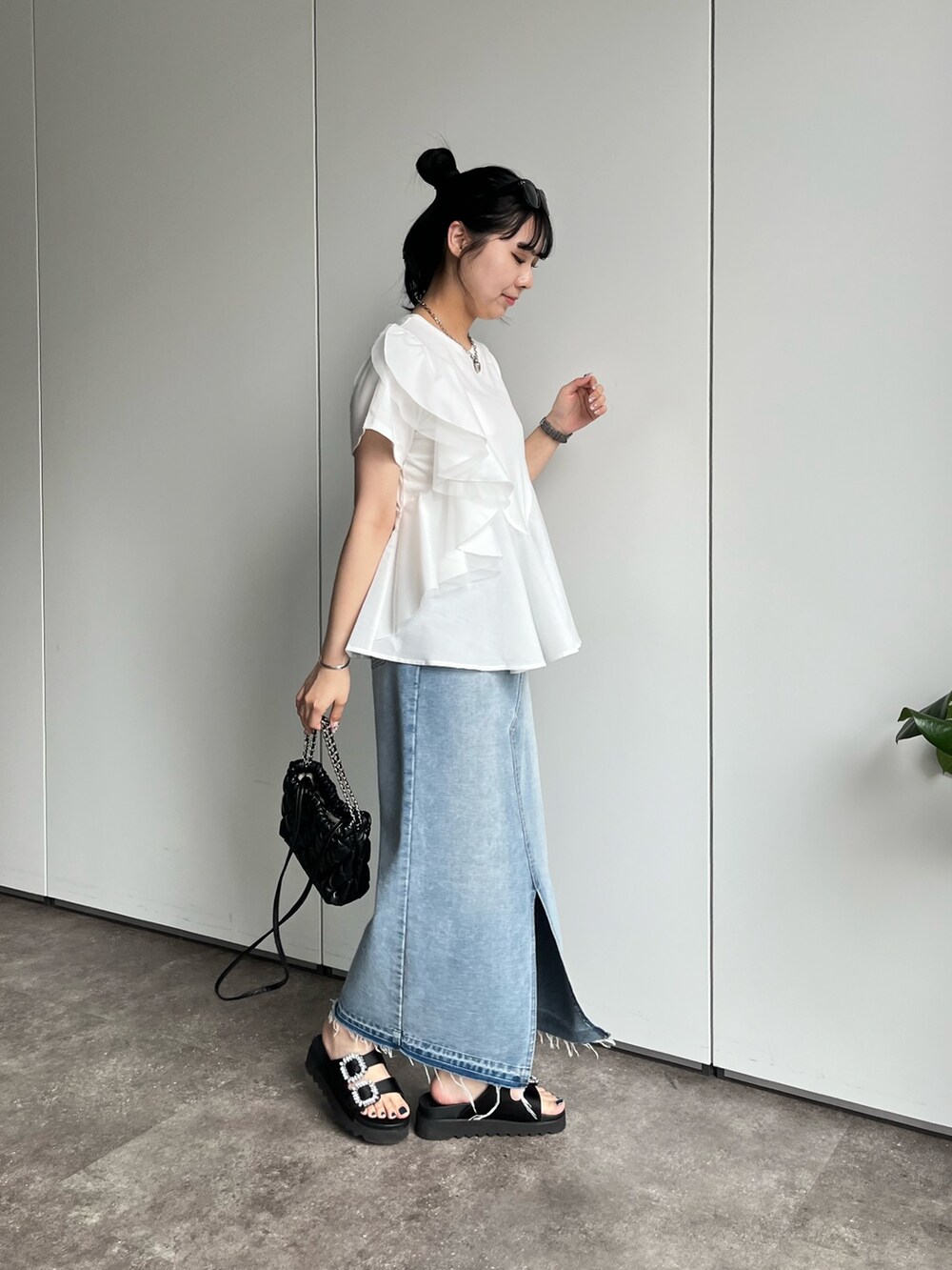 ホワイト系のTシャツ/カットソー、ブルー系のデニムスカート、ブラック系のサンダルを着用したレディースの春コーディネートの2枚目の写真