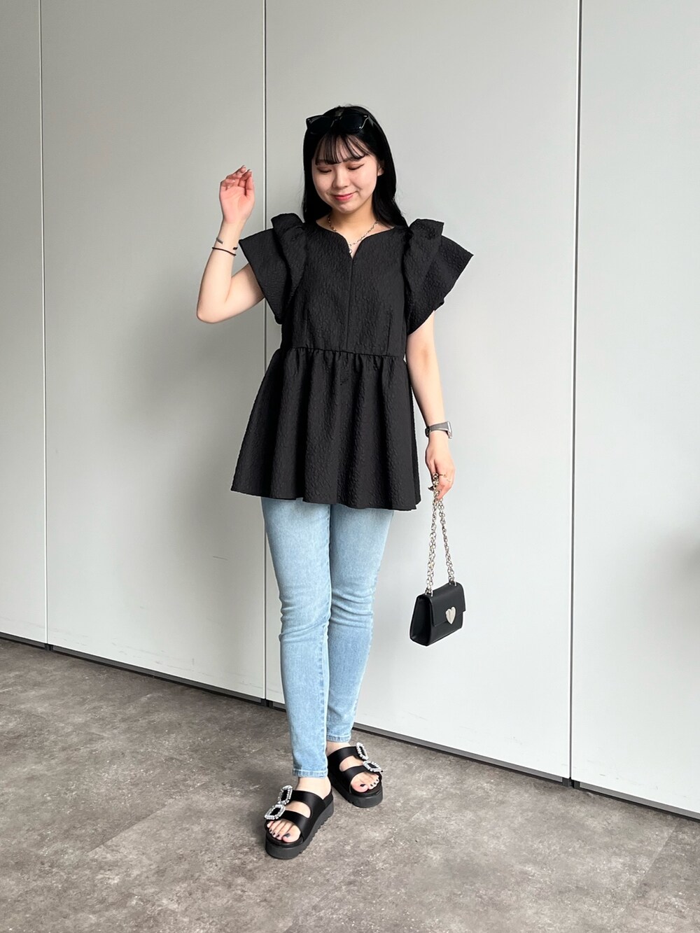 ブラック系のシャツ/ブラウス、ブルー系のデニムパンツ、ブラック系のサンダルを着用したレディースの春コーディネートの3枚目の写真