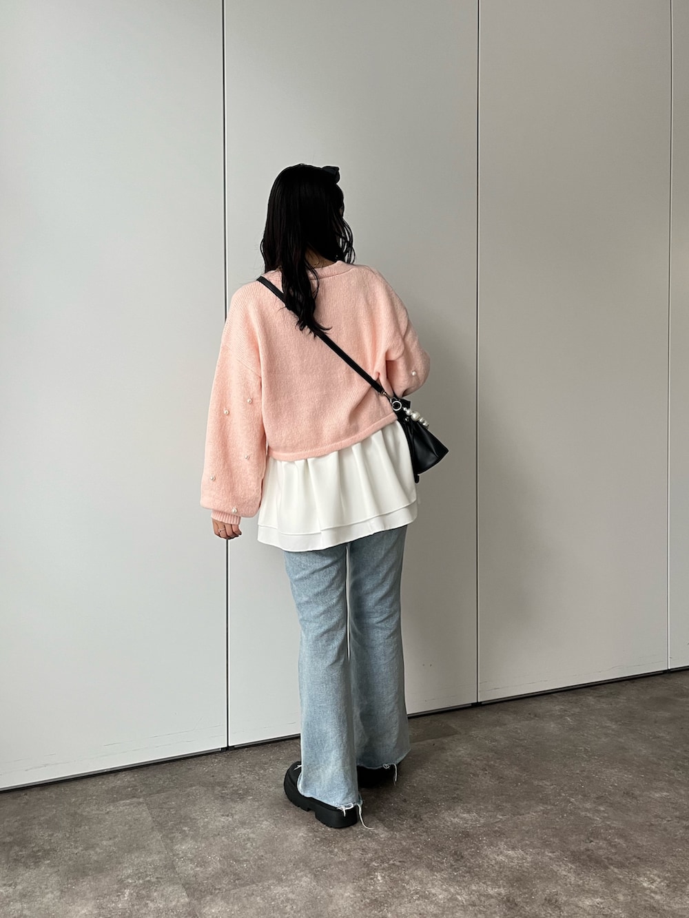 ホワイト系のTシャツ/カットソー、ピンク系のカーディガン/ボレロ、ブルー系のデニムパンツを着用したレディースの秋コーディネートの2枚目の写真