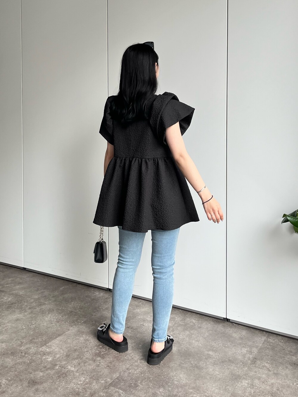 ブラック系のシャツ/ブラウス、ブルー系のデニムパンツ、ブラック系のサンダルを着用したレディースの春コーディネートの2枚目の写真